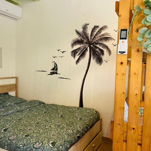 une chambre avec un palmier peint au pochoir sur le mur dans l'établissement Studio calme proche Aix & mer, à Gardanne