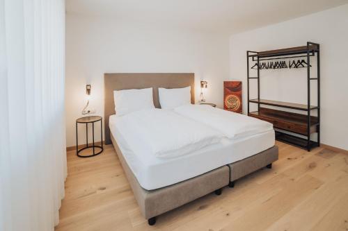 a bedroom with a large bed with white sheets at Apart Suites Gravbach in Lagundo