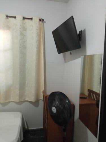 a bathroom with a fan and a television on the wall at Hotel JF in Pirassununga