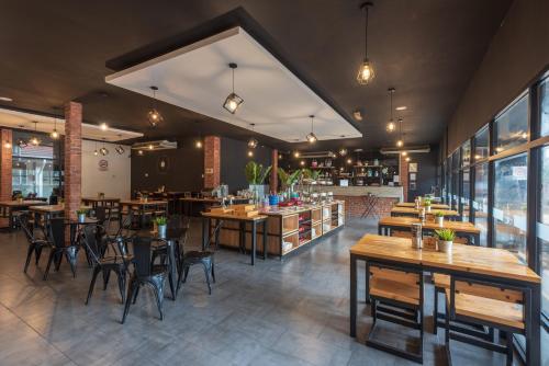 a restaurant with wooden tables and chairs in a room at Hotel Seri Malaysia Ipoh in Ipoh