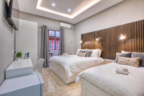 a bedroom with two beds and a couch in it at Hughesville Birgu in Birgu