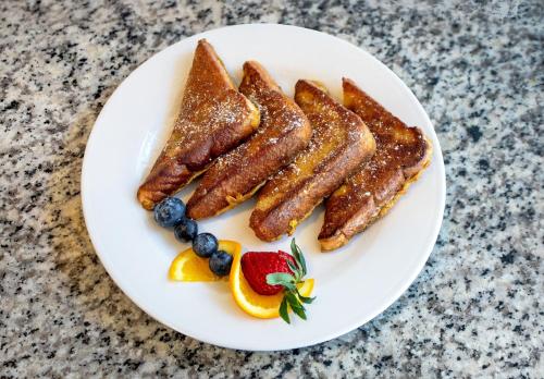 オールドスマーにあるHilton Garden Inn Tampa Northwest/Oldsmarのソーセージとフルーツが添えられた朝食のプレート