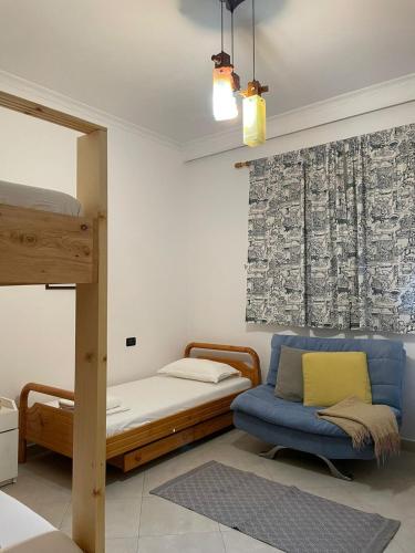 a bedroom with a bunk bed and a blue couch at Casa Shpresë - The Traditional Suite in Tirana