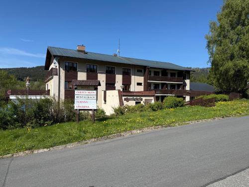 a building with a sign in front of a road at Hotel Čertův Mlýn, Špičák, Železná Ruda, Šumava in Špičák