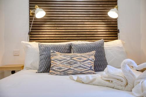a bedroom with a bed with pillows and a headboard at Hughesville Birgu in Birgu