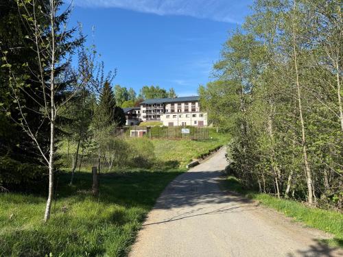 a dirt road with a building in the background at Hotel Čertův Mlýn, Špičák, Železná Ruda, Šumava in Špičák