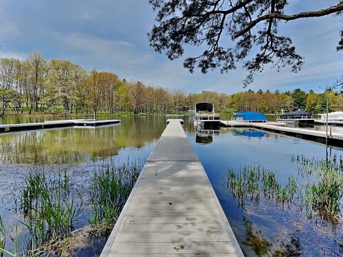 a dock on a river with a boat in the water at Starlit Memories in Swanton