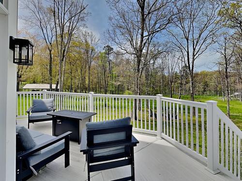a porch with two chairs and a table and a fence at Starlit Memories in Swanton