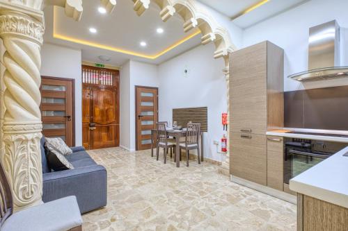 a kitchen and living room with a couch and a table at Hughesville Birgu in Birgu