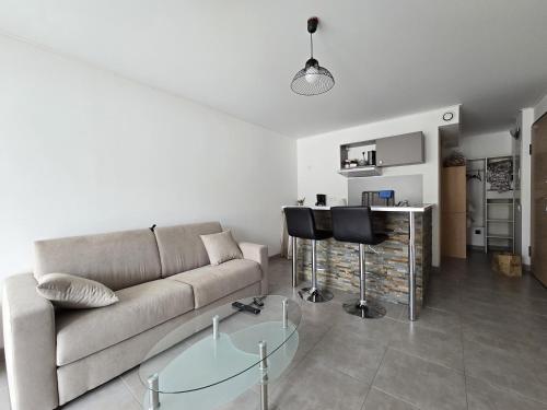 un salon avec un canapé et une table en verre dans l'établissement Charmant studio avec extérieur, à Corte
