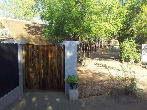 a wooden fence with a potted plant next to a yard at Off Beat Safaris Bush Lodge in Hoedspruit