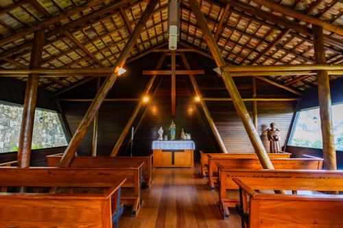 a row of wooden pews in a church at Putini Pousada e Hotel by OYO in São Roque