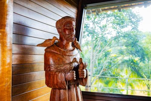 a statue of a man standing in front of a window at Putini Pousada e Hotel by OYO in São Roque