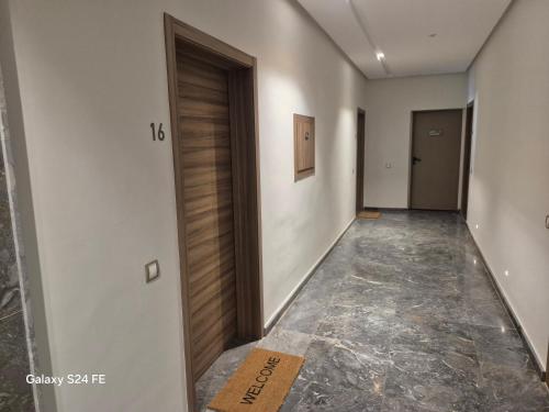 a hallway with a wooden door in a building at aeroperla 11 aeroprt casa blanca in Nouaseur