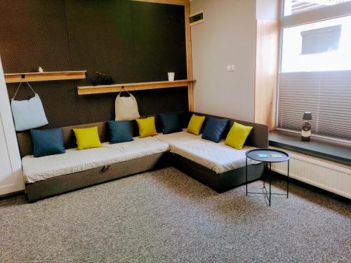 a living room with a couch with yellow and blue pillows at Apartament Na Reymonta in Starogard Gdański