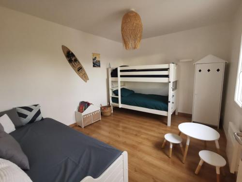 - une chambre avec des lits superposés, une table et des chaises dans l'établissement villa near ocean with swimming pool, à Bias