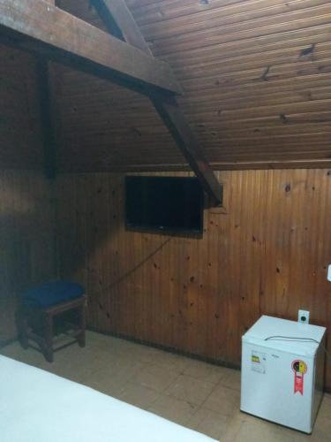 a room with a tv on a wooden wall at Hotel JF in Pirassununga