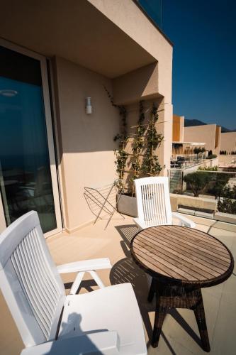 a patio with a table and two chairs and a table at Whisky Green Coast Hotel & Apartments in Palasë