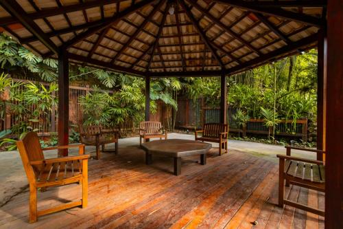 a pavilion with benches and a table on a wooden deck at Putini Pousada e Hotel by OYO in São Roque