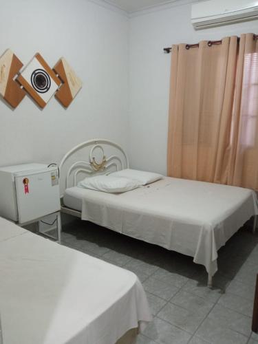 a bedroom with two beds and a camera on the wall at Hotel JF in Pirassununga