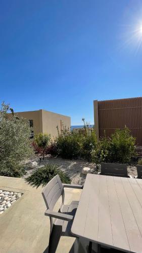 a picnic table and two chairs sitting next to a building at Whisky Green Coast Hotel & Apartments in Palasë