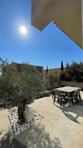 a picnic table and a tree in a patio at Whisky Green Coast Hotel & Apartments in Palasë