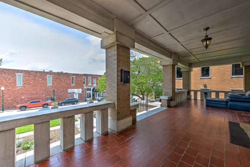 an open porch with a brick building and a brick floor at The Uptown Suite at The Historic Connely Harrington in Siloam Springs