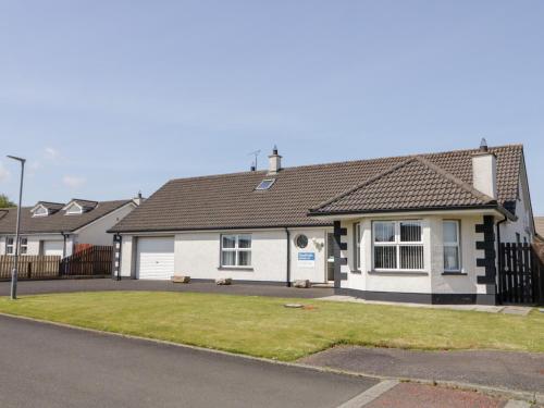 a white house with a black roof at SeaShells in Coleraine
