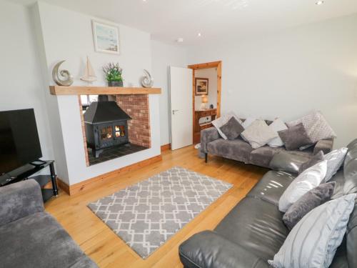 a living room with a couch and a fireplace at SeaShells in Coleraine