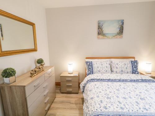 a bedroom with a bed and a dresser at SeaShells in Coleraine