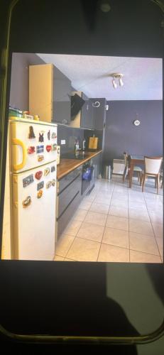 une cuisine avec un réfrigérateur blanc et une table dans l'établissement Agnan, à La Celle-sous-Gouzon