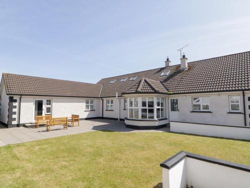 a house with a patio and a bench in the yard at SeaShells in Coleraine