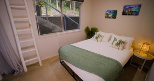 a bedroom with a bed and a window at Majestic Views - Stylish Home in Lower Beechmont
