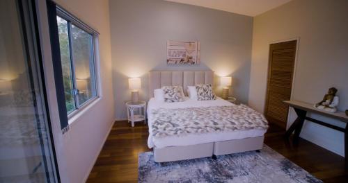 a bedroom with a bed and a window at Majestic Views - Stylish Home in Lower Beechmont