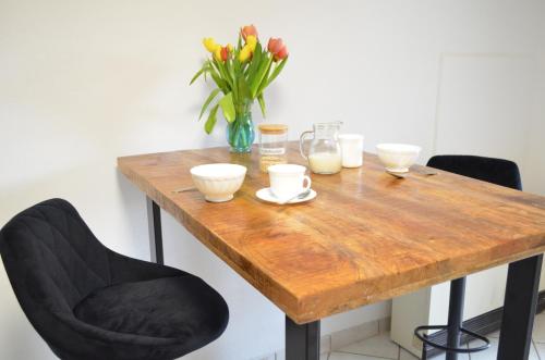 a wooden table with a vase of flowers on it at Ferienwohnung am Reichenbach in Hechingen