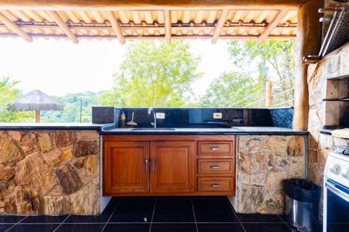 an outdoor kitchen with a sink and a stove at Putini Pousada e Hotel by OYO in São Roque