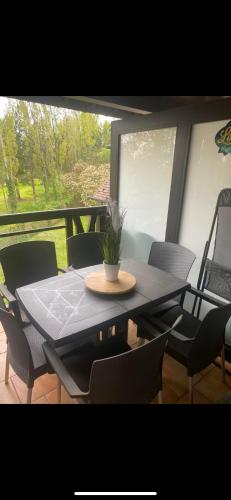 une table avec des chaises et une plante en pot dans l'établissement birdie-deauville, à Deauville
