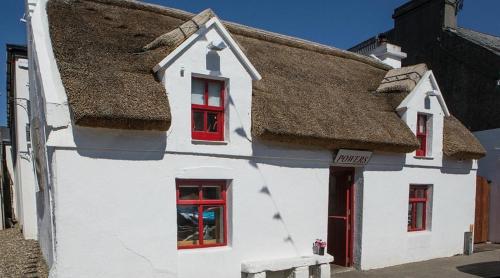 a white house with red windows and a roof at Fabulous 4 Bedroom House, Gateway to Connemara in Galway