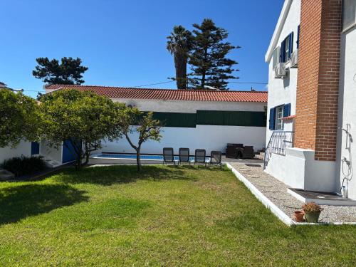 a yard with two chairs and a building at Casa do Rei Aroeira in Charneca