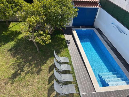 an overhead view of a swimming pool with chairs next to it at Casa do Rei Aroeira in Charneca