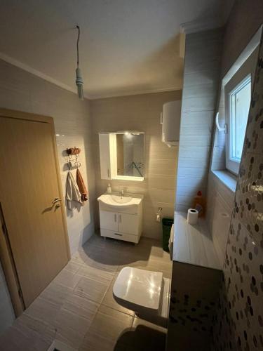 een badkamer met een wastafel, een toilet en een spiegel bij Buća Potok Aurrora in Sarajevo
