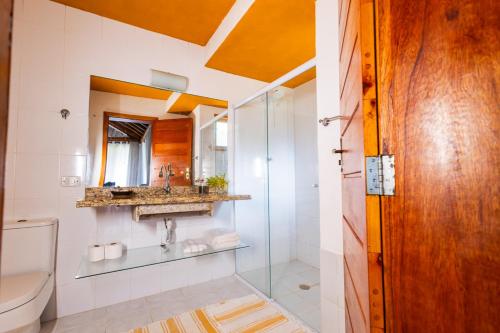 a bathroom with a shower and a toilet and a sink at Putini Pousada e Hotel by OYO in São Roque