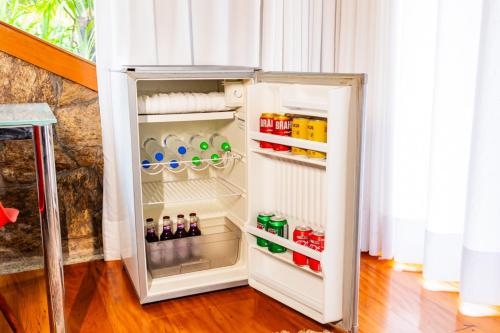 an open refrigerator filled with lots of drinks at Putini Pousada e Hotel by OYO in São Roque