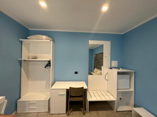a room with a table and a chair and a blue wall at Soulmondo Beach Rooms in Campomarino