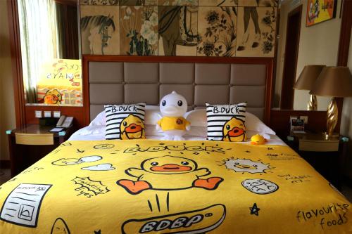 a bed with a yellow comforter with a group of people on it at Kempinski Hotel Shenzhen - 24 Hours Stay Privilege, Subject to Hotel Inventory in Shenzhen