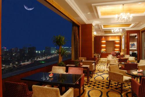 a restaurant with a view of the city at night at Kempinski Hotel Shenzhen - 24 Hours Stay Privilege, Subject to Hotel Inventory in Shenzhen