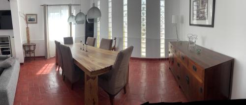 a dining room with a wooden table and chairs at Casa do Rei Aroeira in Charneca