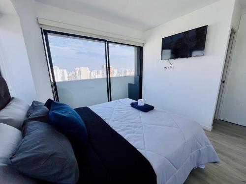 a bedroom with a bed and a large window at Hermoso departamento en el Centro de Lima in Lima