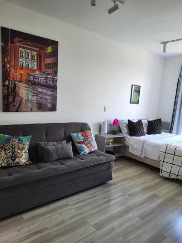 a living room with a couch and a bed at Studio with a beautiful view in Curitiba