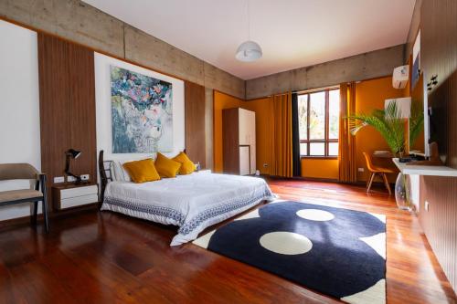 a bedroom with a bed with yellow pillows and a rug at Putini Pousada e Hotel by OYO in São Roque